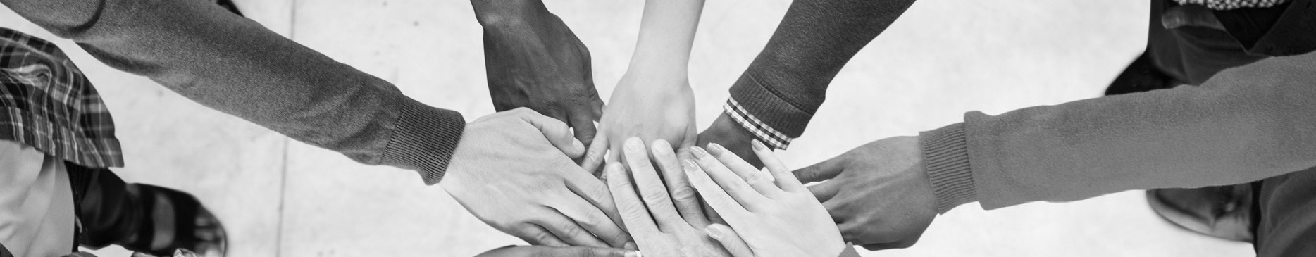 Black and White image of many hands on top of each other